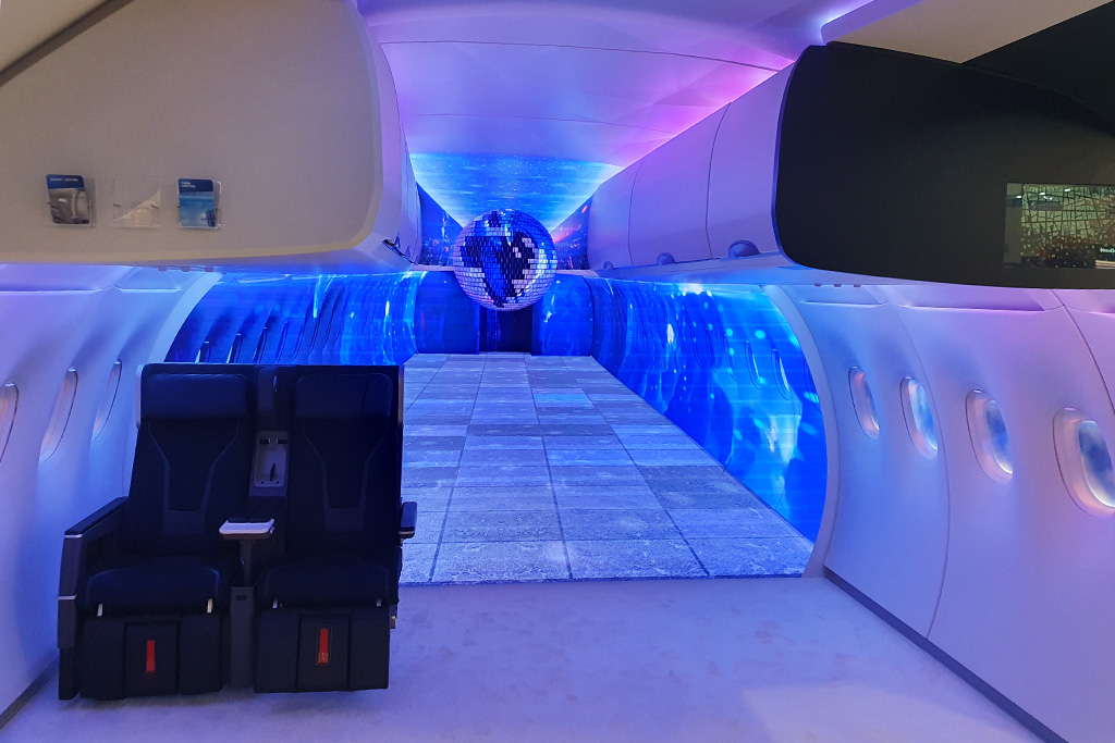 Partystimmung mit Diskokugel und buntes Licht in der Flugzeugkabine 