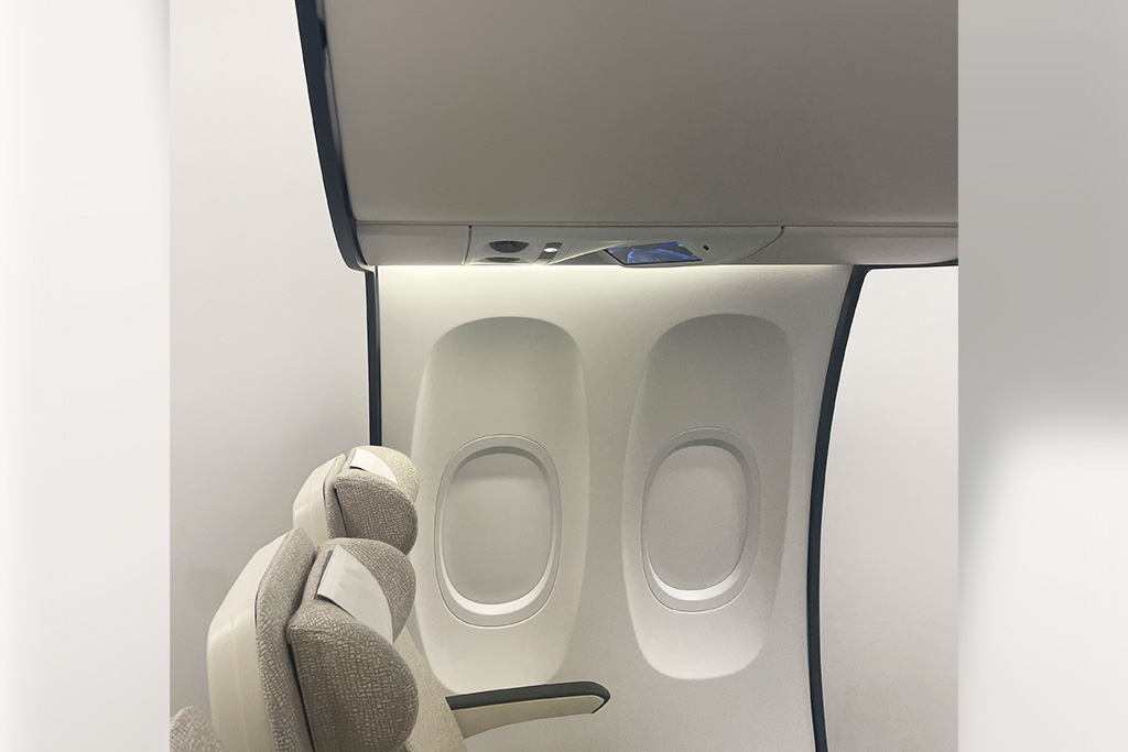 eine Flugzeugsitzreihe mit beleuchteter Seitenwand und Passenger Service Unit als Touchdisplay