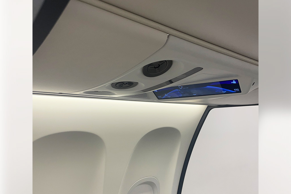 Nahansicht eine Flugzeugsitzreihe mit beleuchteter Seitenwand und Passenger Service Unit als Touchdisplay